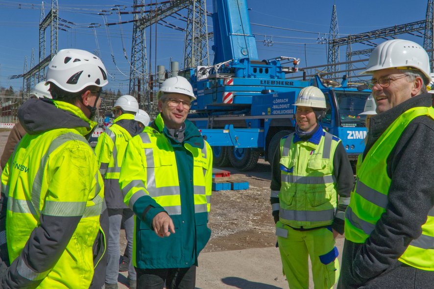 Jens Hilbert, Projektleiter von TransnetBW für Umbau und Modernisierung des Umspannwerks Kühmoos, (2. V.l.) erklärt Landrat Dr. Martin Kistler (r.) Details der geplanten Maßnahmen direkt vor Ort. Das Landratsamt hat mehrere Maßnahmen von TransnetBW inzwischen nach Bundesimmissionsschutzgesetz genehmigt.