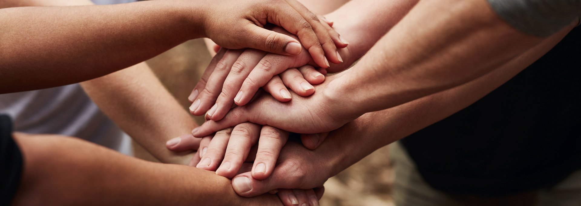 Viele Hände von Menschen unterschiedlichen Alters liegen aufeinander