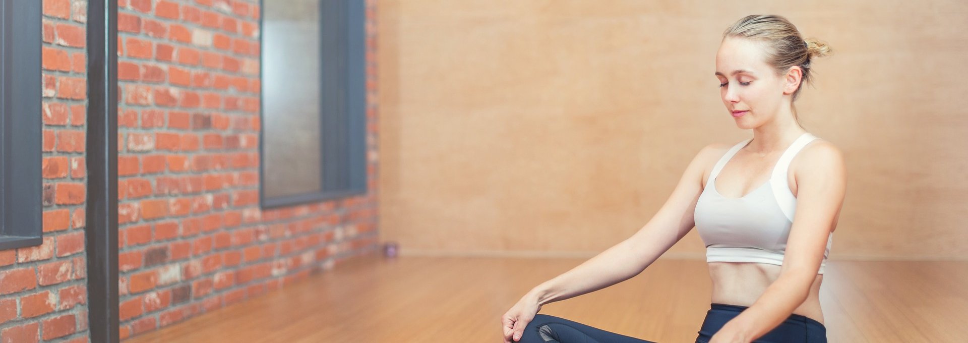 Frau auf Fitnessmatte macht Yoga